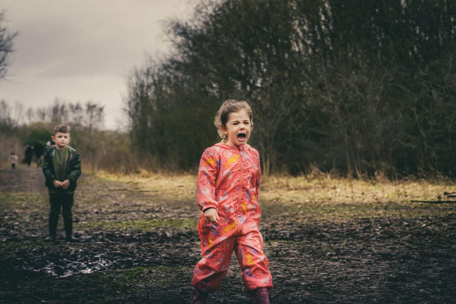 Young girl walking away from boy, crying