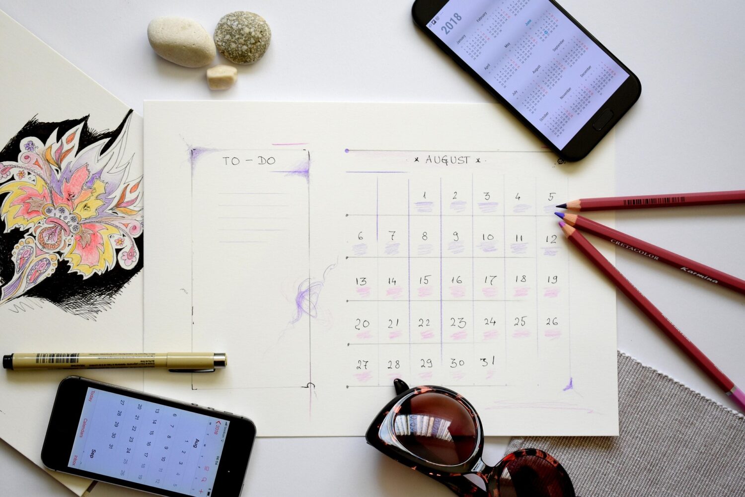 Calendar with phone and sunglasses on a desk