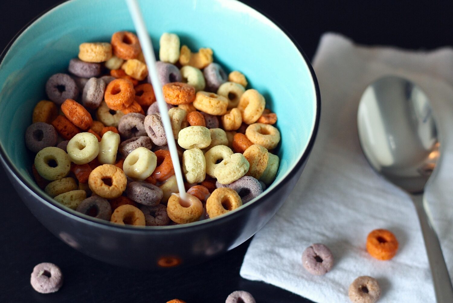 Bowl of colorful cereal and milk with spoon