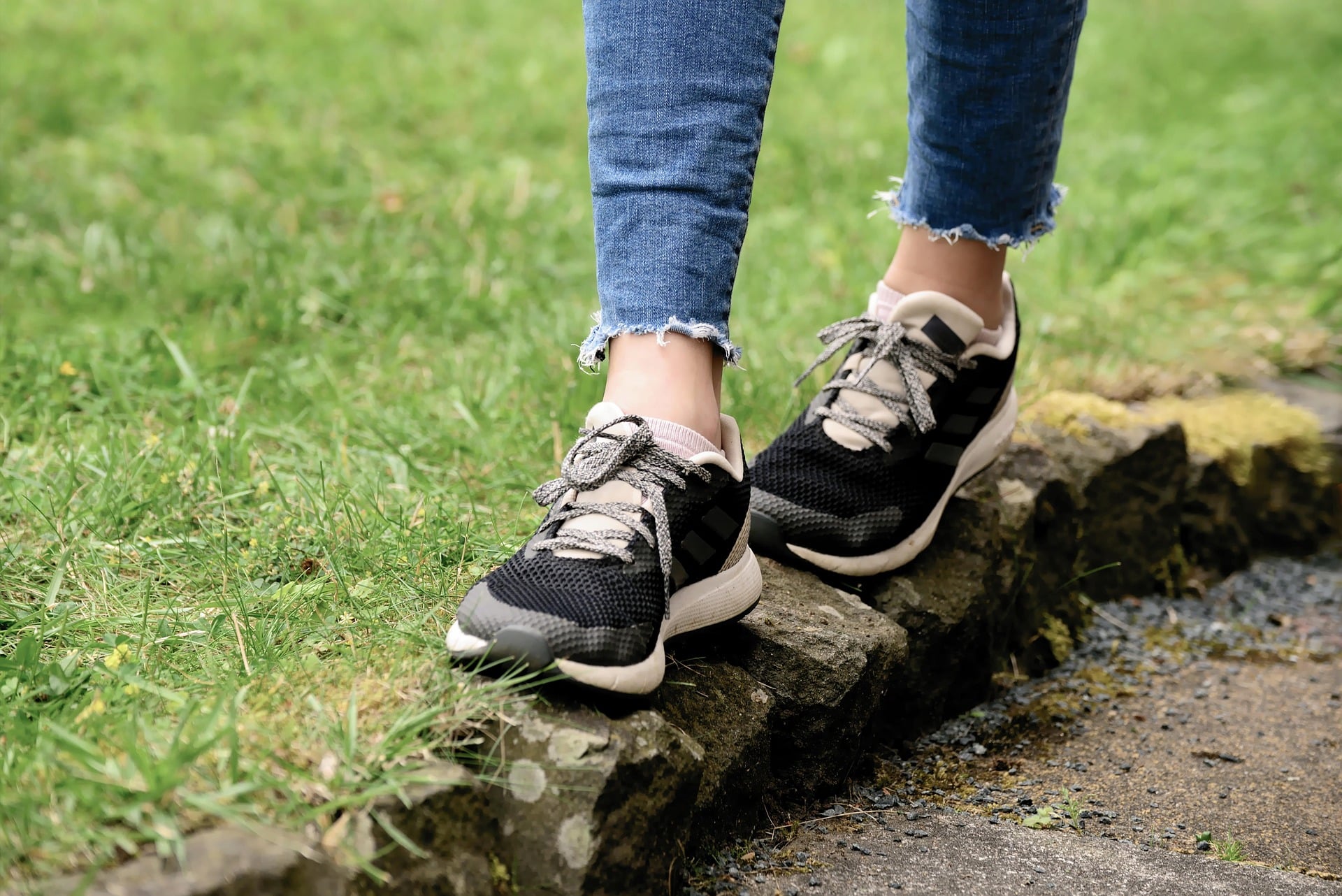 Close up of a person's feet balancing on a path of stones