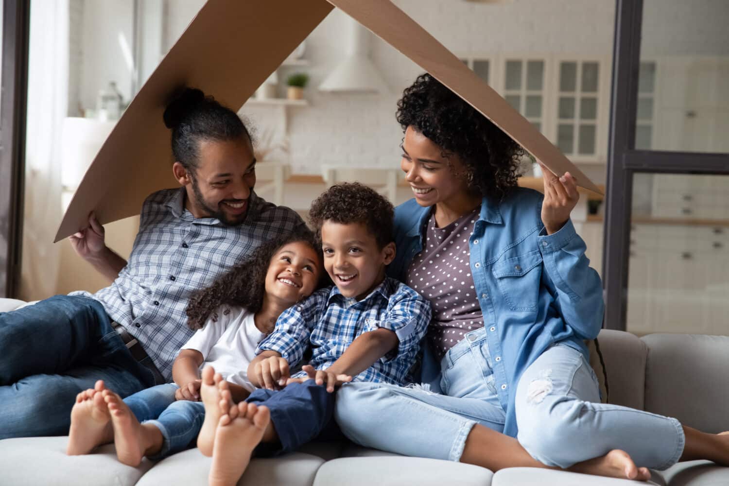 Cute Black family playing under cardboard roof