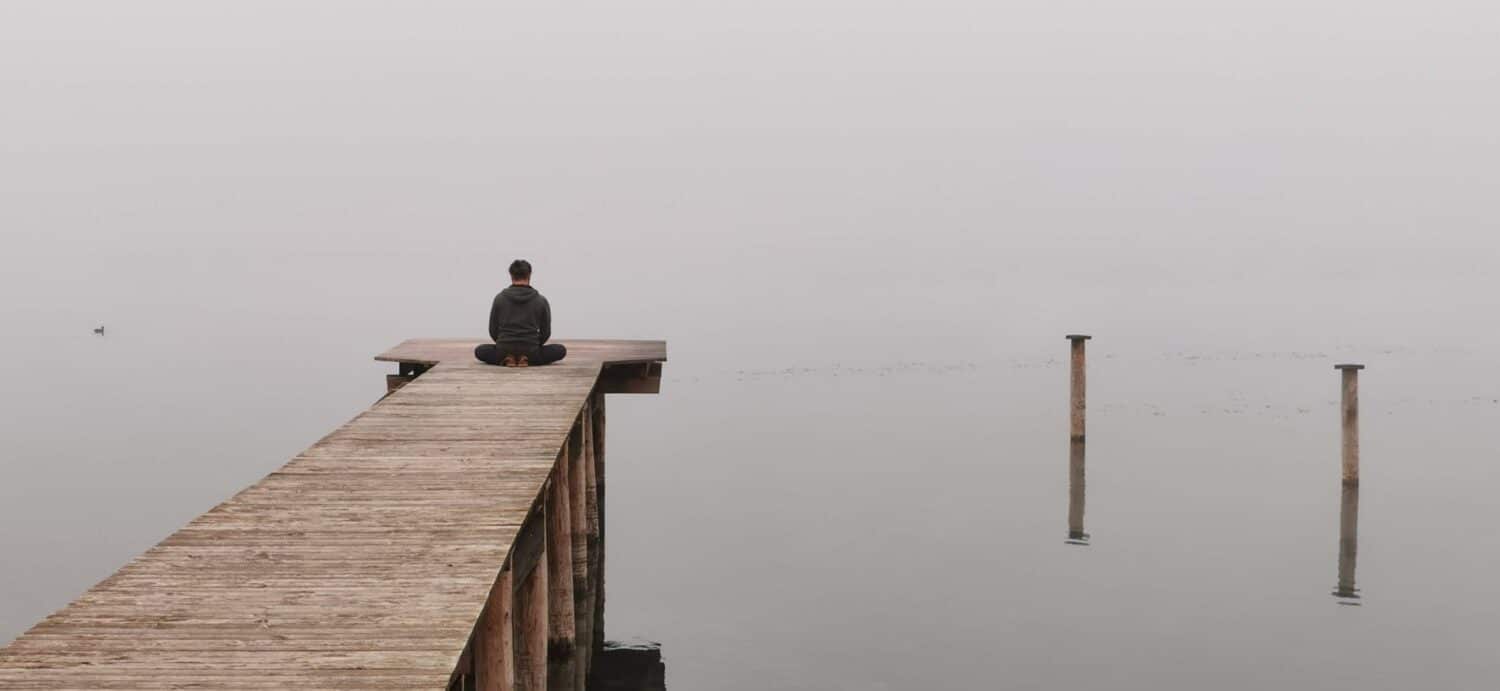 A person sitting at the end of a dock