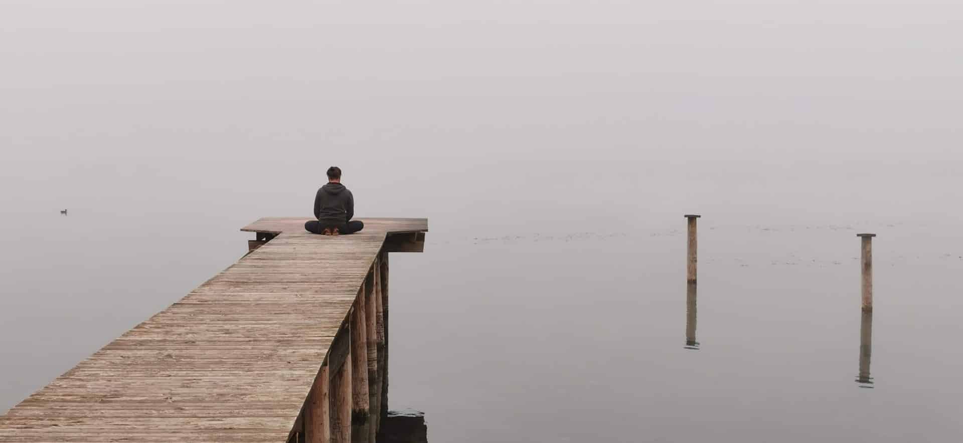 A person sitting at the end of a dock