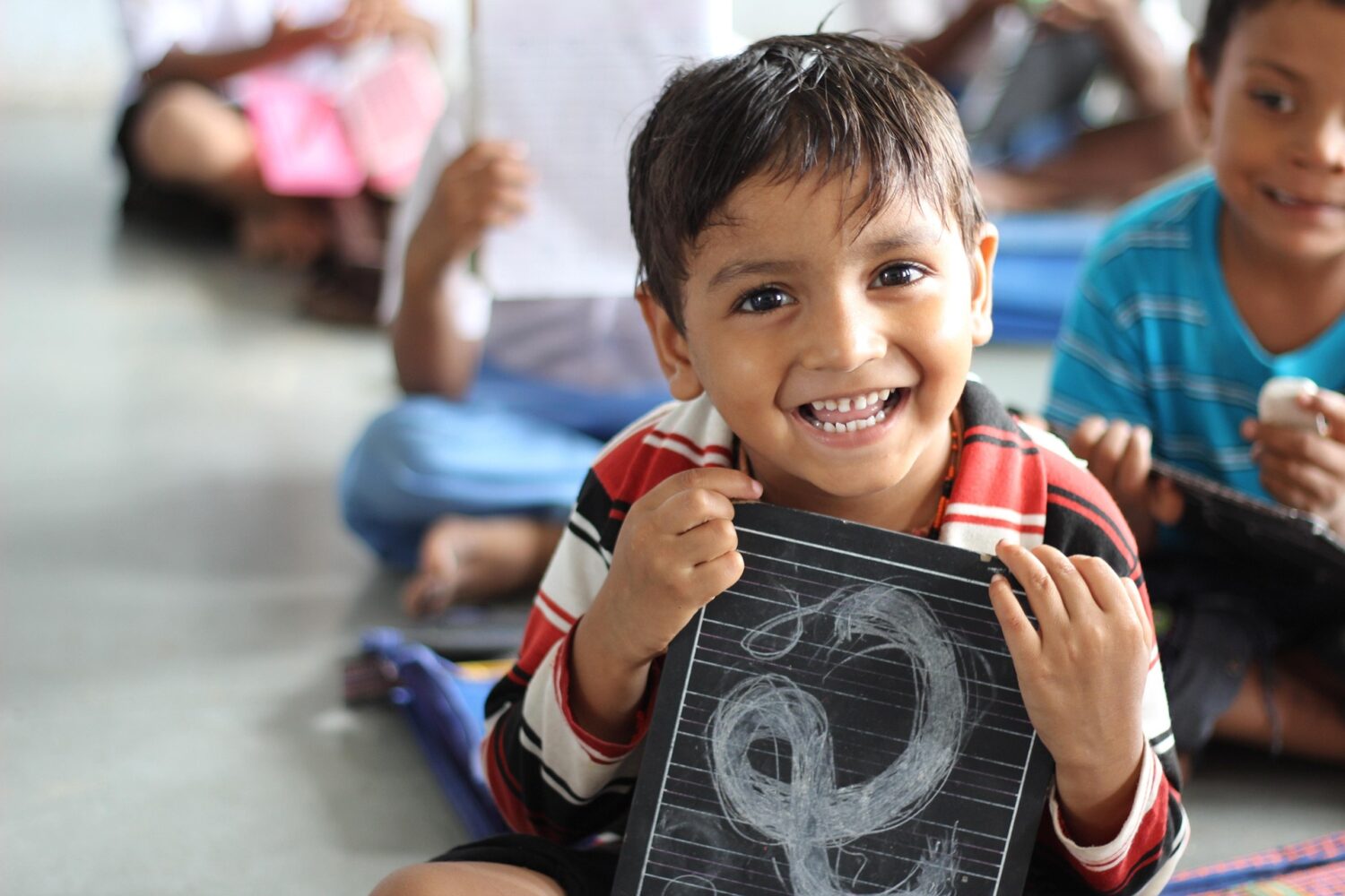 Smiling boy holding chalkboard