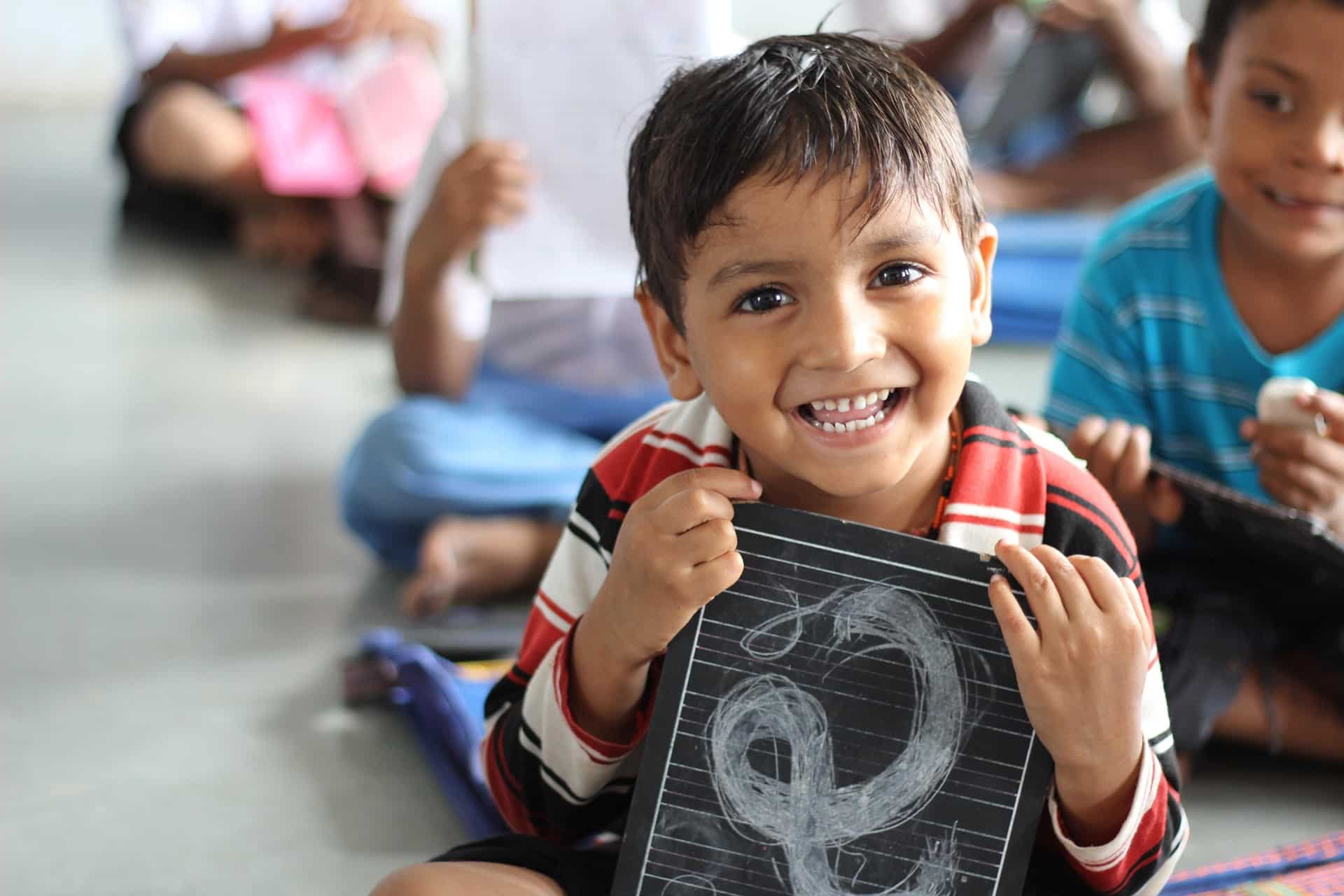 Smiling boy holding chalkboard
