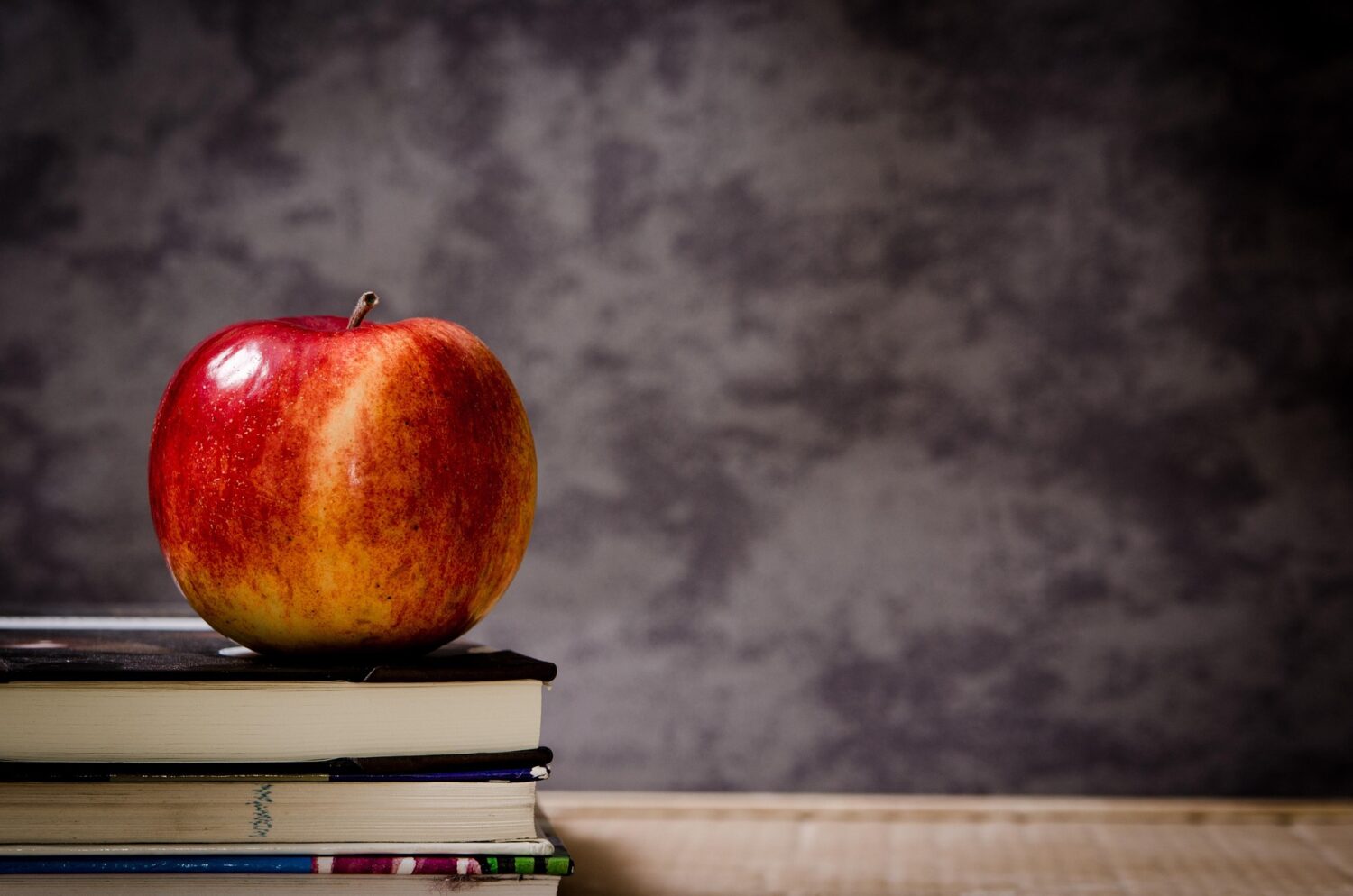 Apple on a stack of books in a classroom