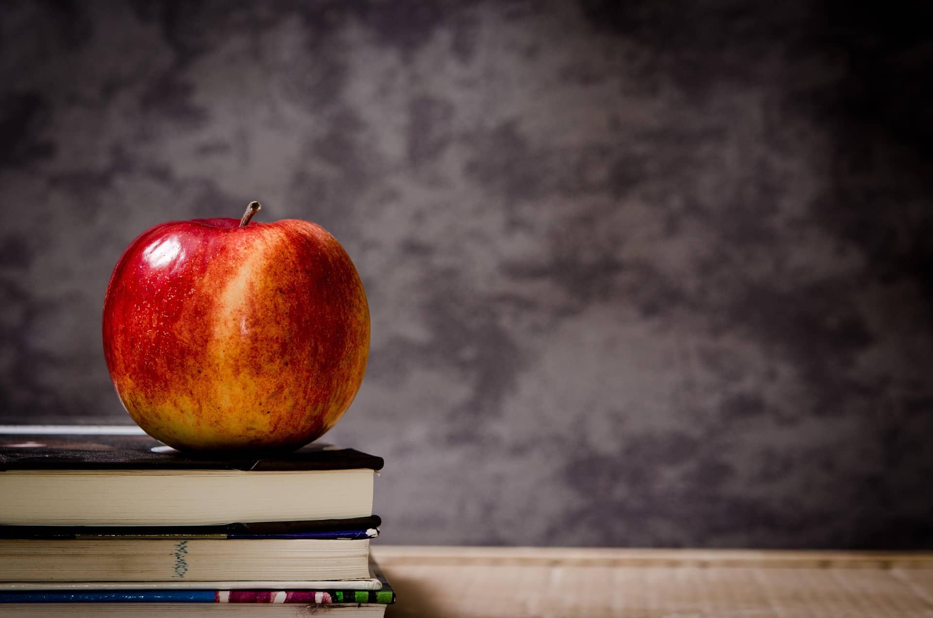Apple on a stack of books in a classroom