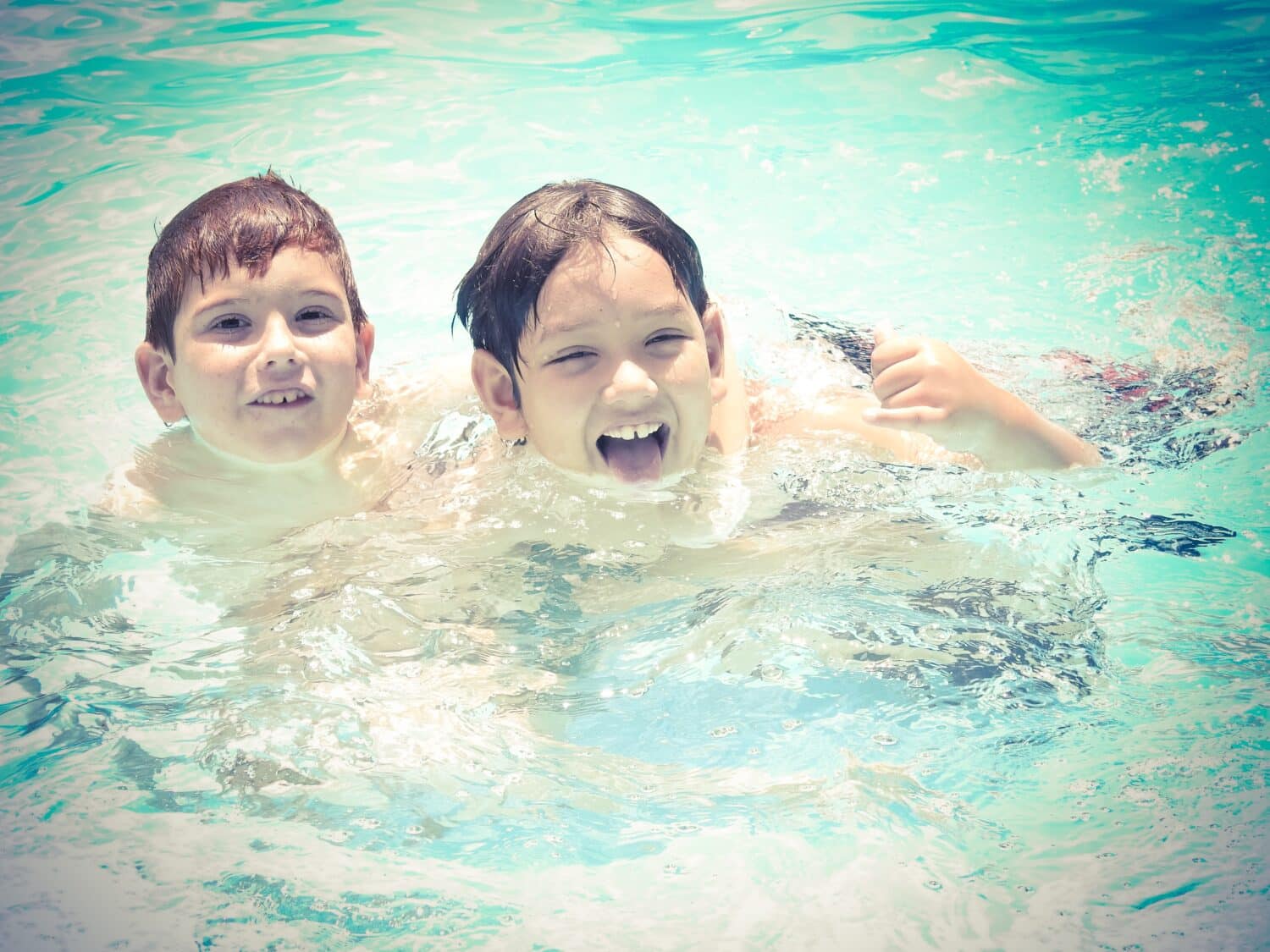 Two kids swimming in a pool