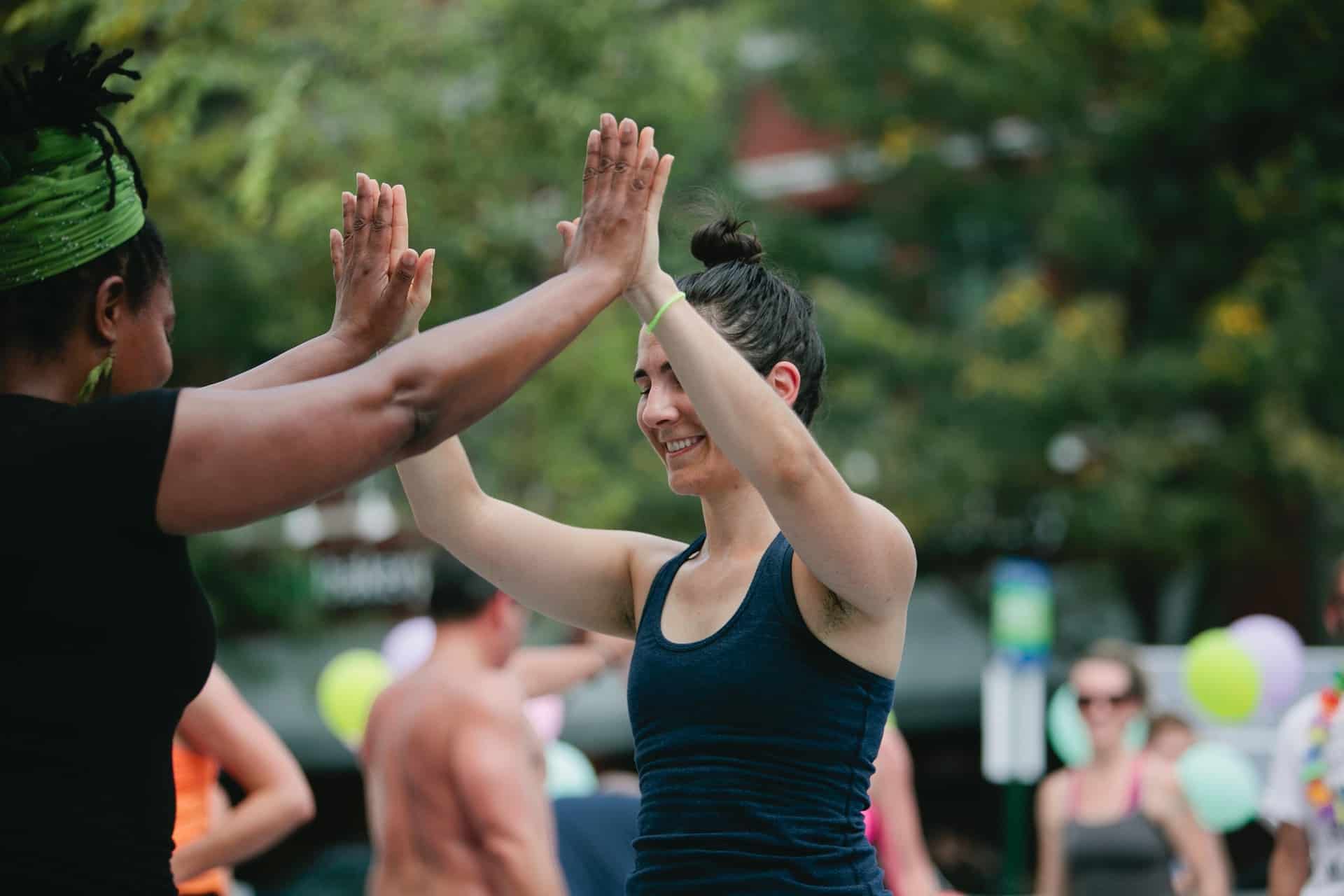 Two women high five in park