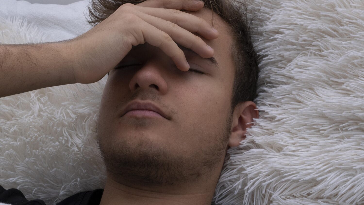Tired male with hand over closed eyes