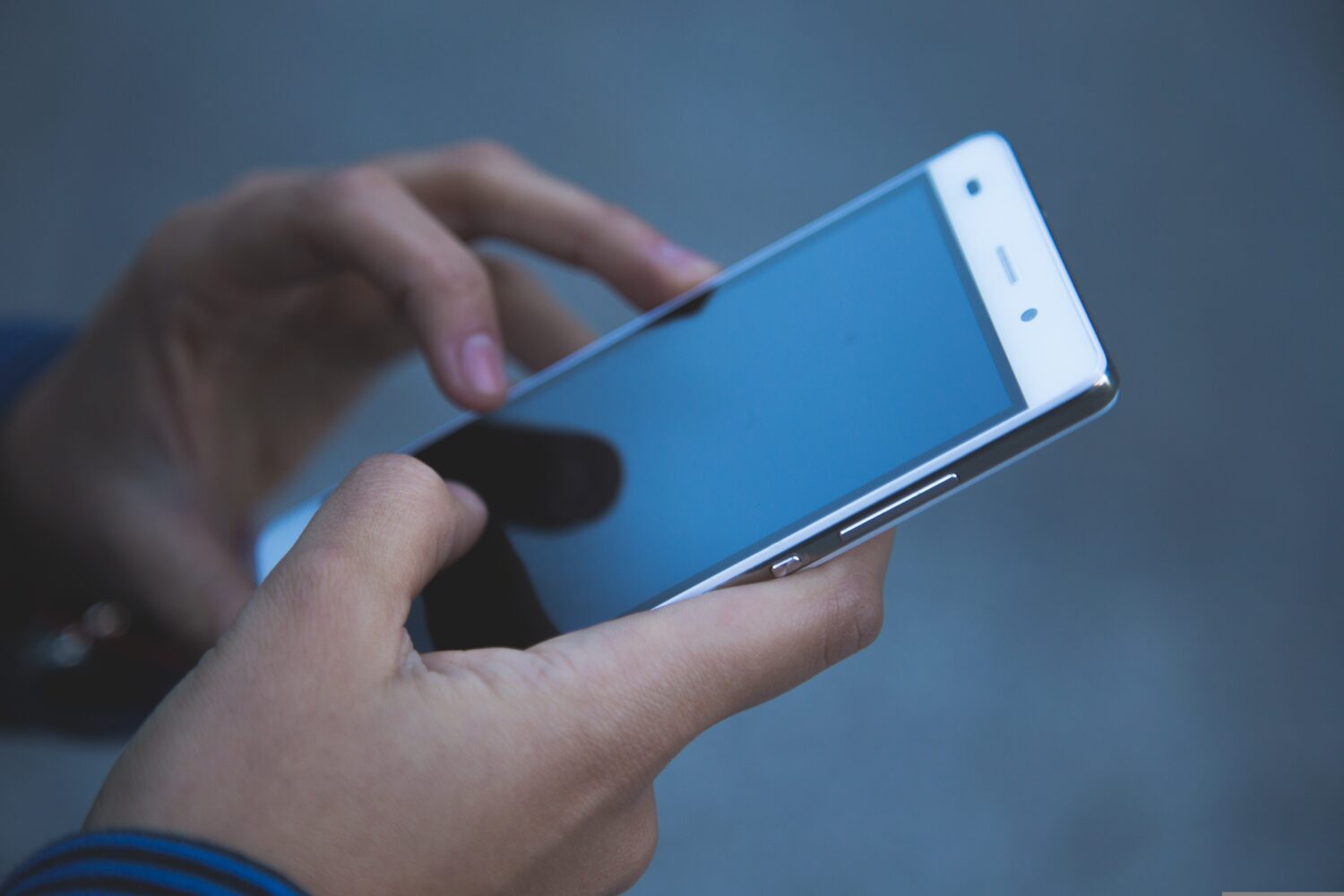 Close up of hands holding mobile phone