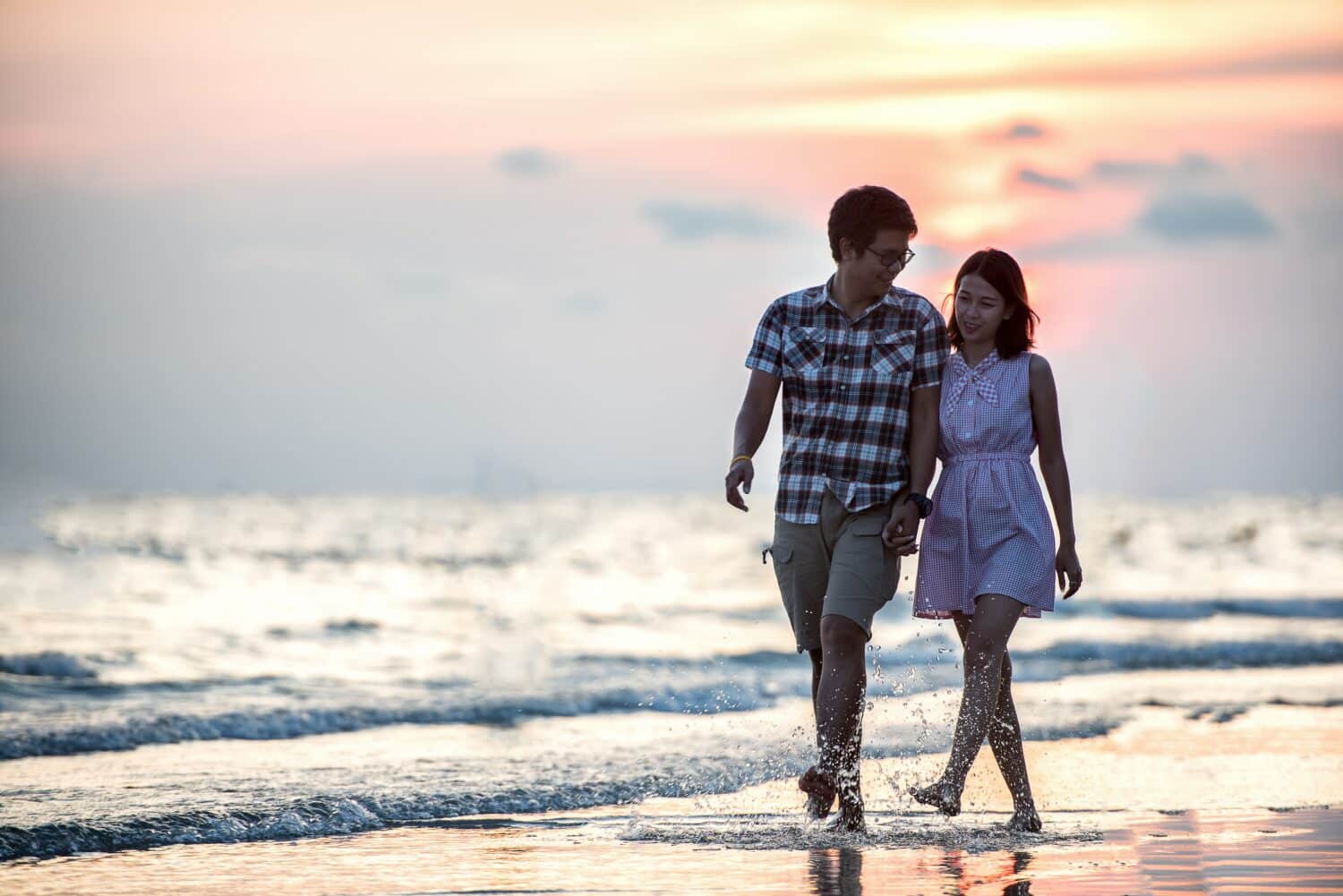 Smiling couple walks on beach