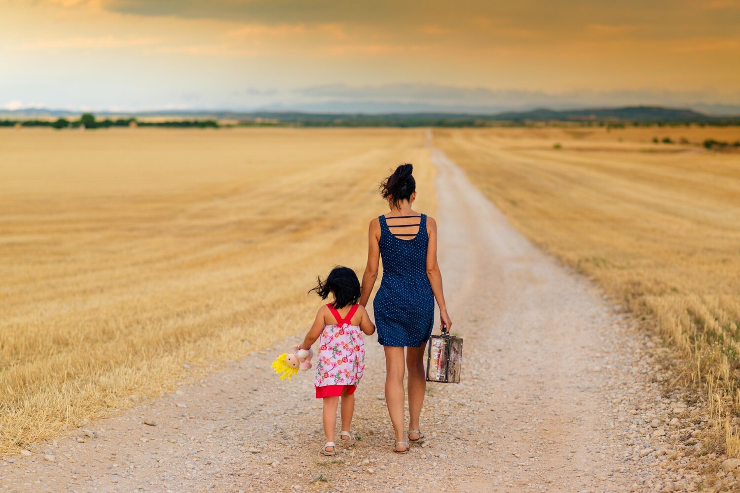 Adult and child walking in a field