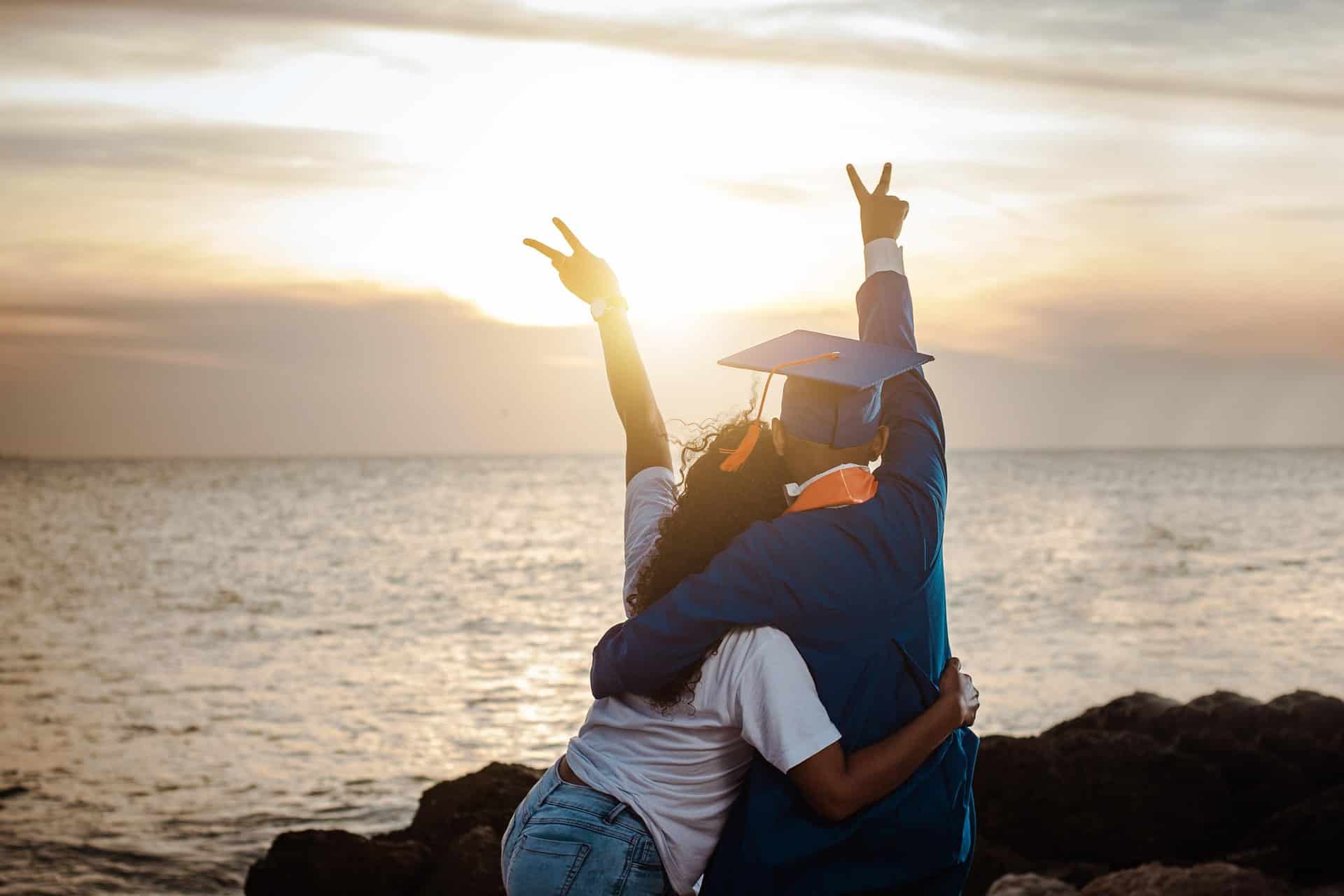 Graduate celebrates in sunset on beach